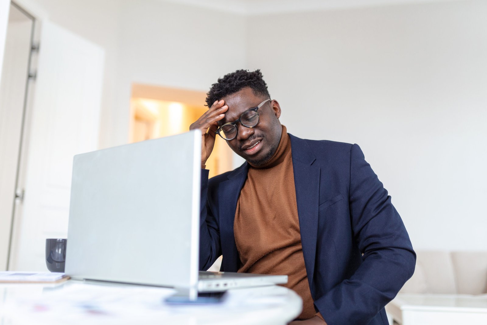 Stressed tired African American man touching temples, suffering from headache after long hours work, overworked overwhelmed businessman sitting at desk, feeling unwell